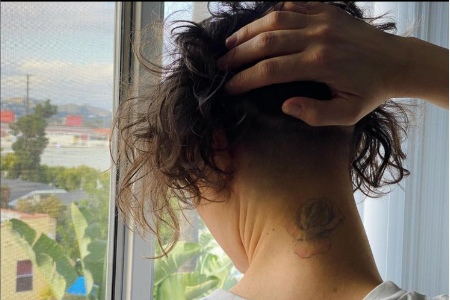 Picture of Russo's Tattoo of flower in her back neck. 